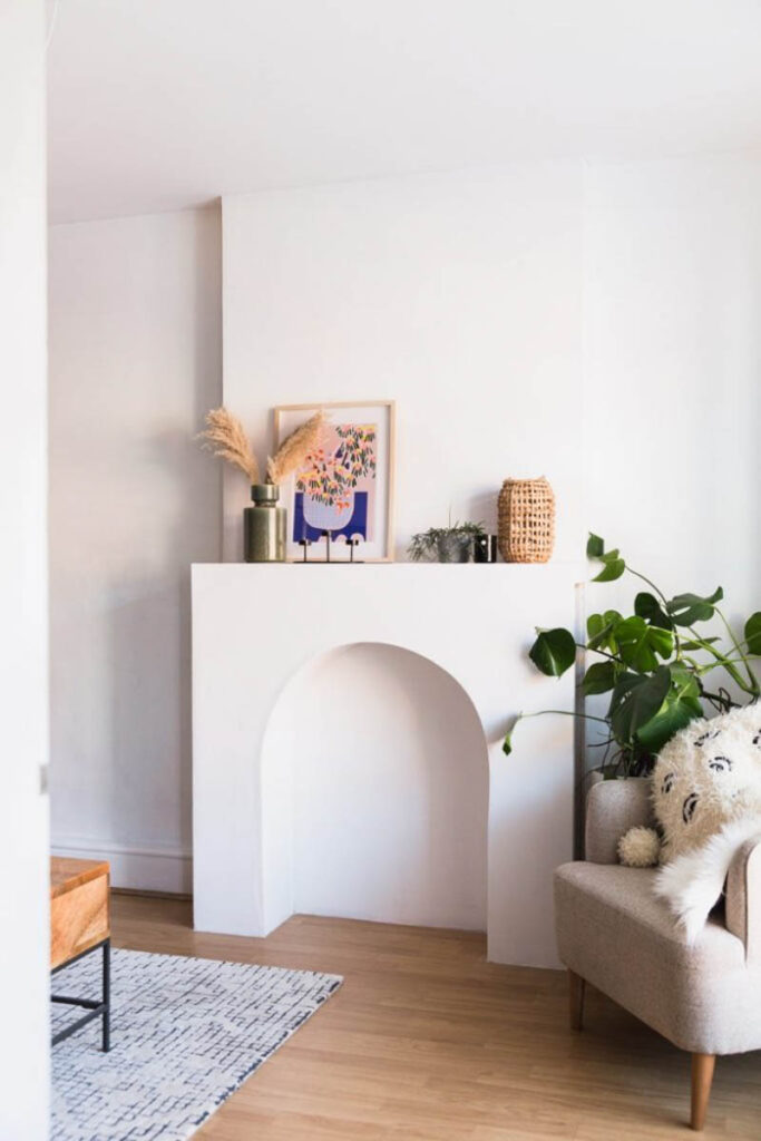 Built-in arched faux fireplace with decor on the mantle 