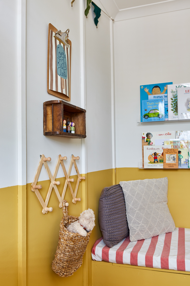 The wooden panelling, half painted wall and reading nook are shown in this photo. A corner of the room. The bookshelves are clear 