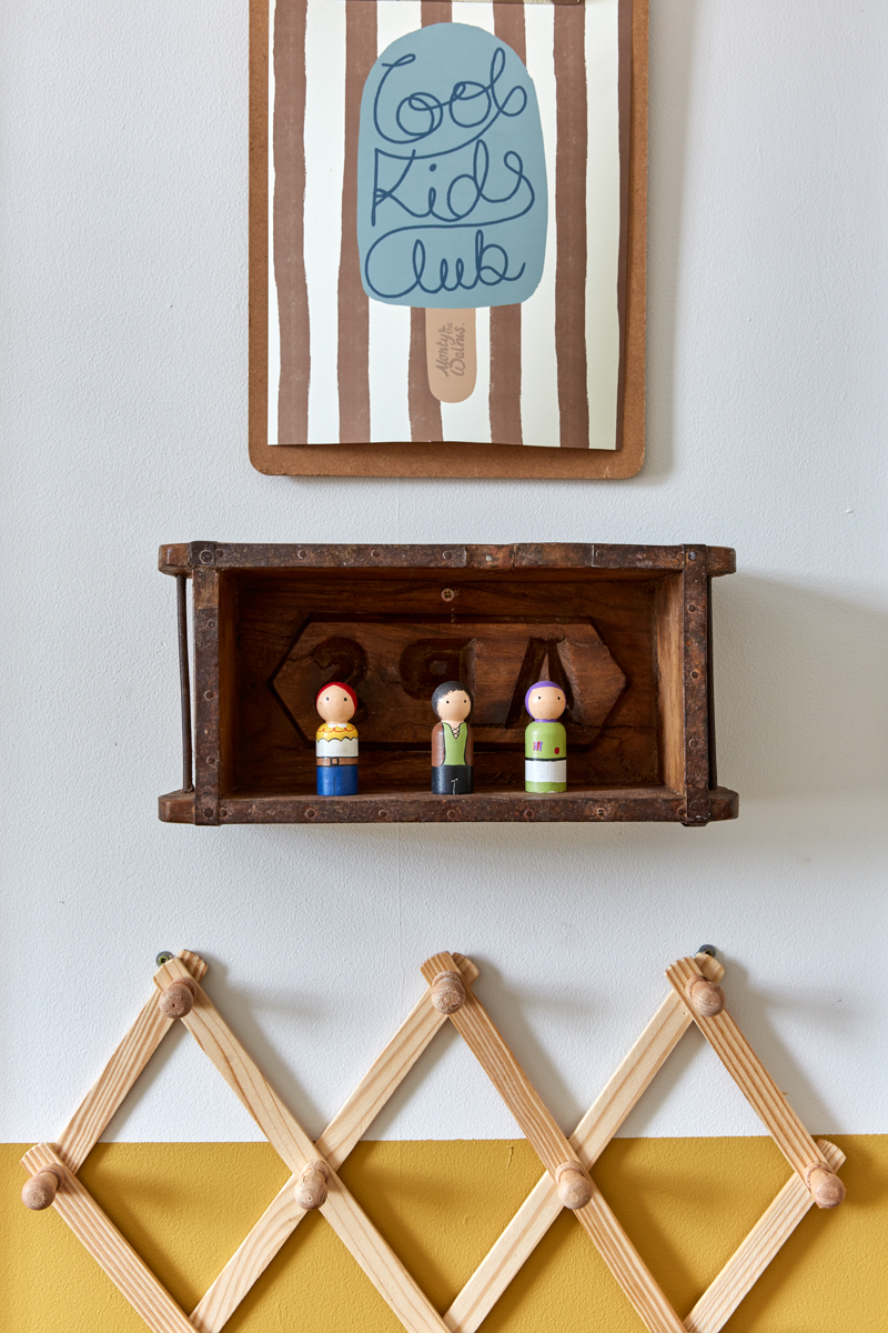 A close up of the vintage box as a shelf and the artwork which reads cool kids club